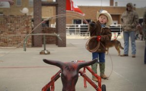 kid lassoing toy bull in nebraska