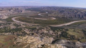 aerial of river running through theodore roosevelt national park